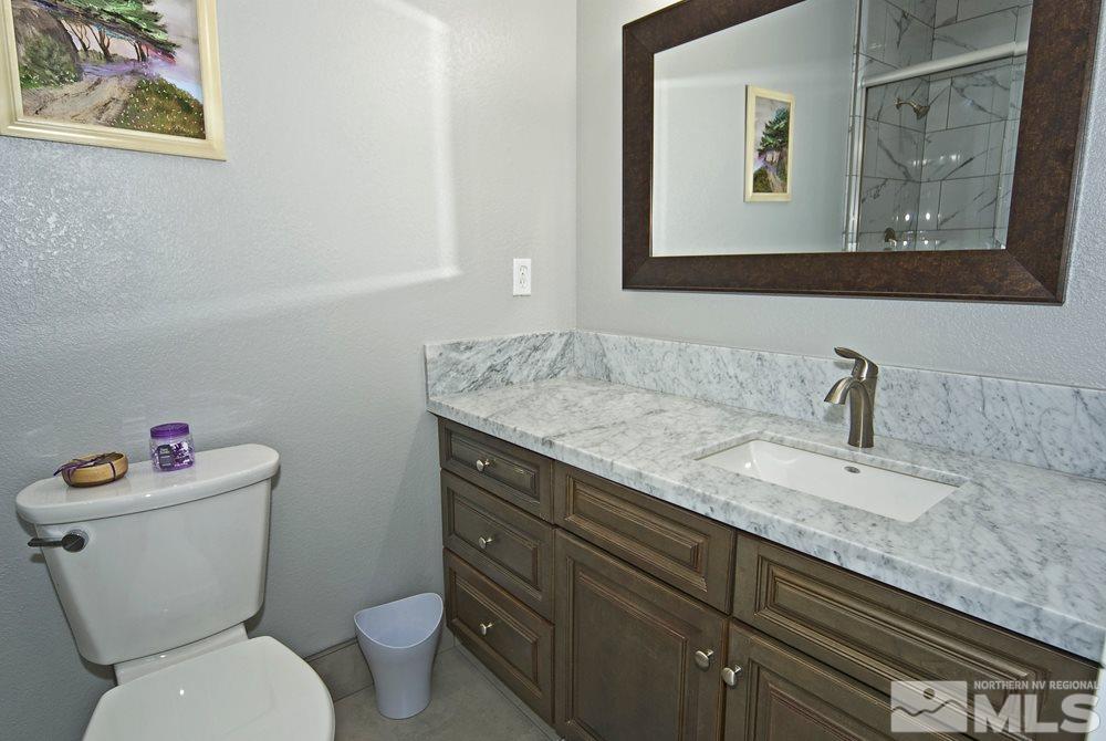 1375 Freds Mountain Road Reno, NV 89508 - Photo 24 of 40 a bathroom with a granite countertop toilet sink and mirror