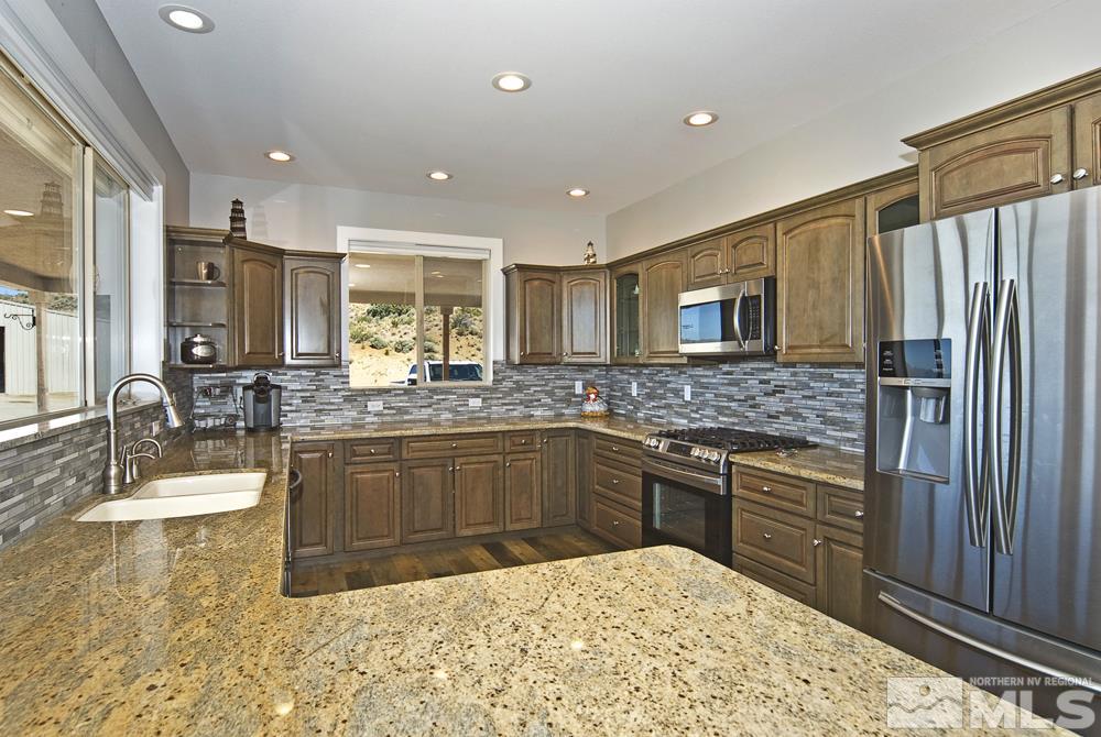 1375 Freds Mountain Road Reno, NV 89508 - Photo 8 of 40 a kitchen with stainless steel appliances granite countertop a sink stove and refrigerator