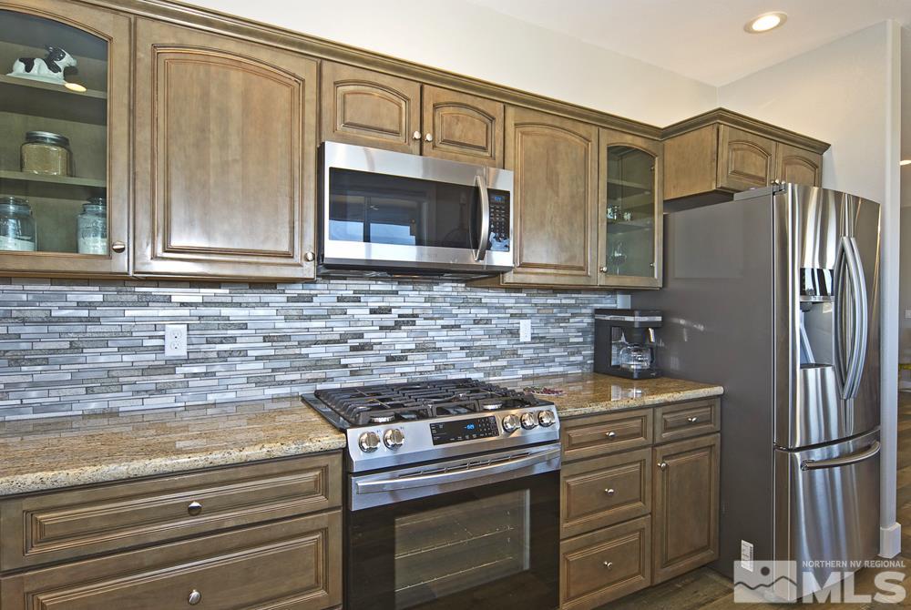 1375 Freds Mountain Road Reno, NV 89508 - Photo 10 of 40 a kitchen with stainless steel appliances granite countertop a refrigerator stove and cabinets