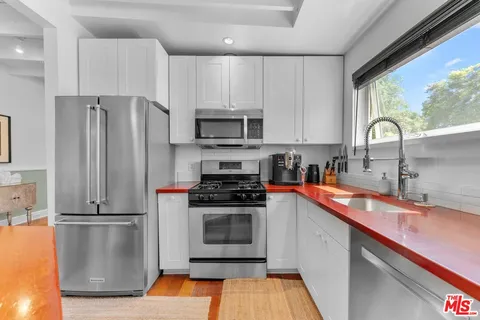 a kitchen with stainless steel appliances granite countertop a refrigerator sink and stove