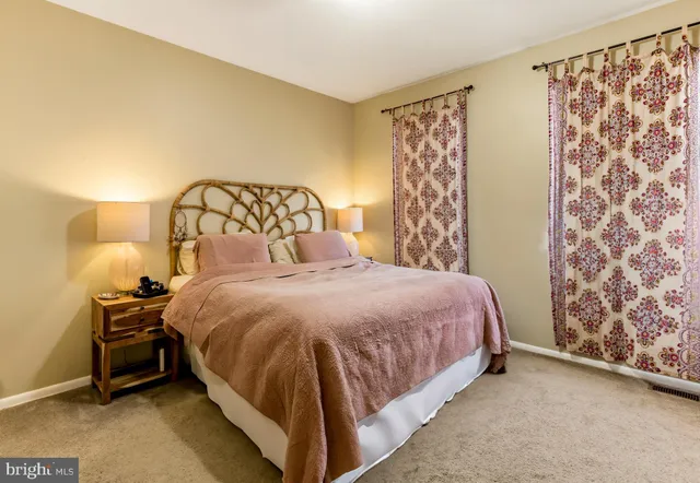 a bed sitting in a bedroom next to a lamp