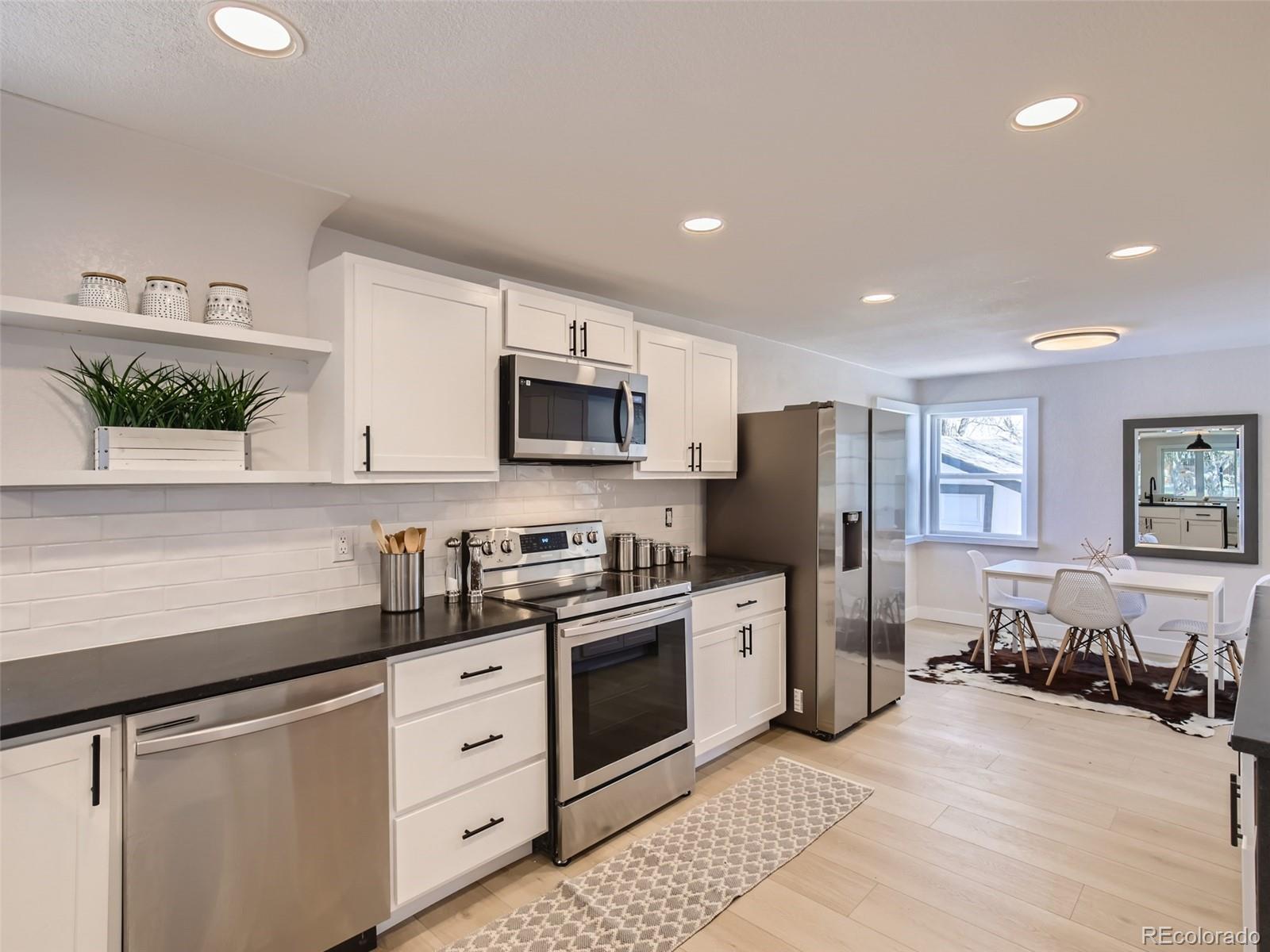 2814 Chase Street Wheat Ridge, CO 80214 - Photo 13 of 28 a kitchen with stainless steel appliances a refrigerator sink and microwave