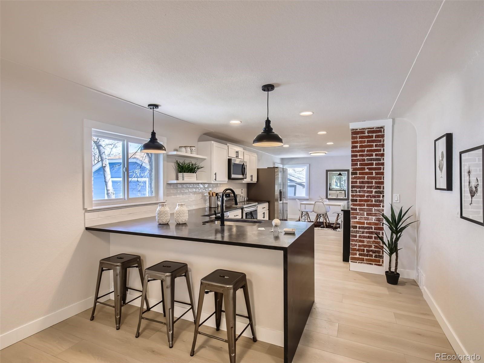 2814 Chase Street Wheat Ridge, CO 80214 - Photo 14 of 28 a kitchen with stainless steel appliances granite countertop a sink and a refrigerator