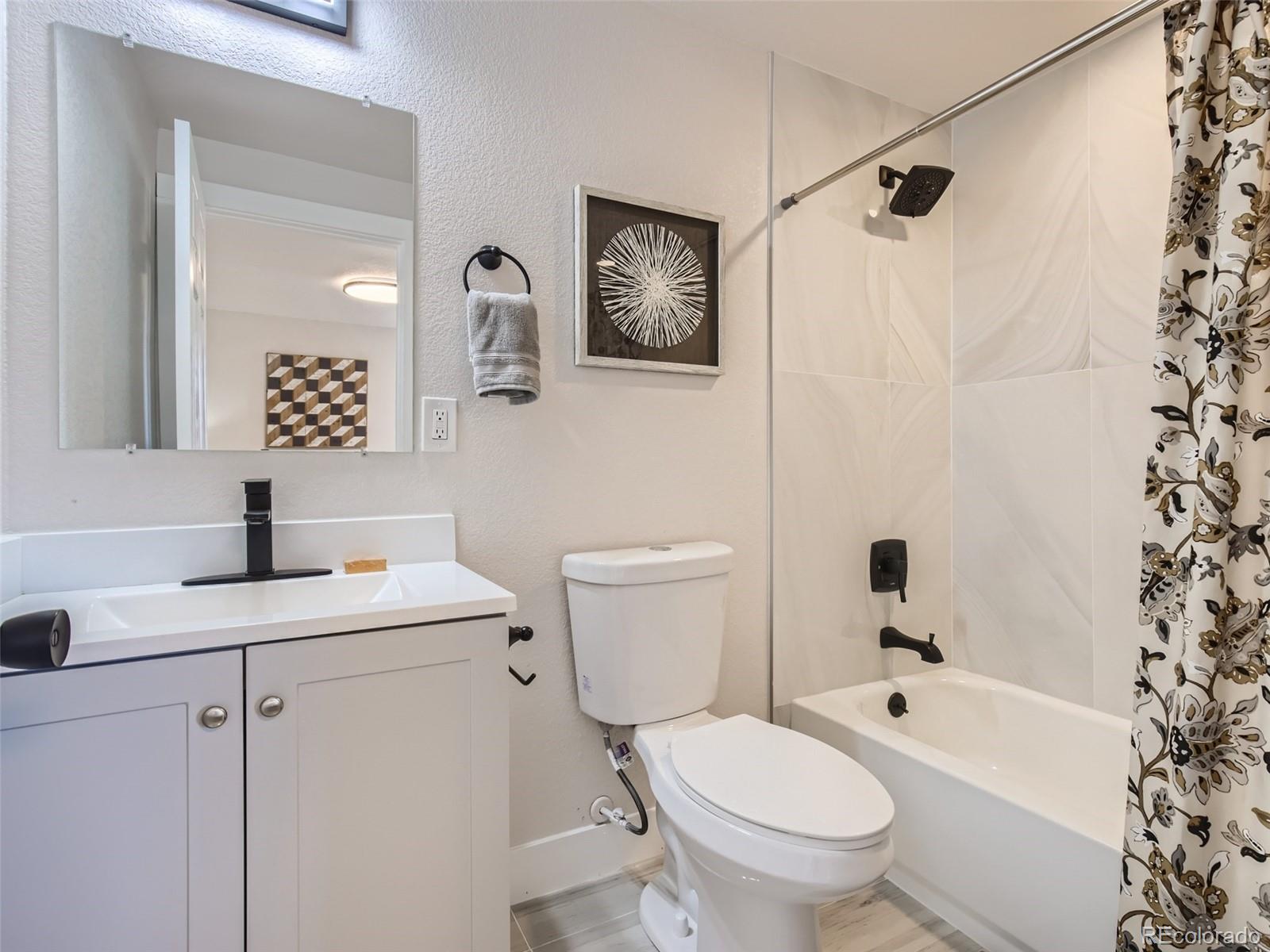 2814 Chase Street Wheat Ridge, CO 80214 - Photo 19 of 28 a bathroom with a toilet sink vanity tub and shower