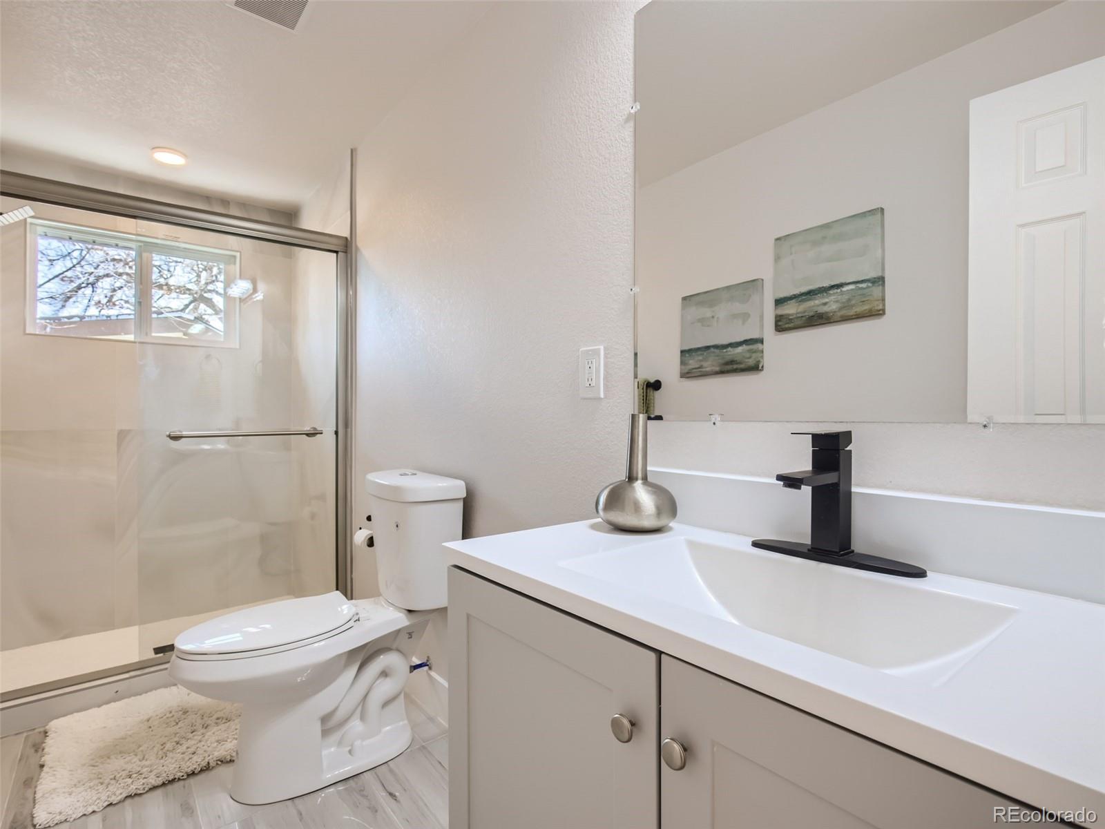 2814 Chase Street Wheat Ridge, CO 80214 - Photo 22 of 28 a bathroom with a sink a toilet and shower