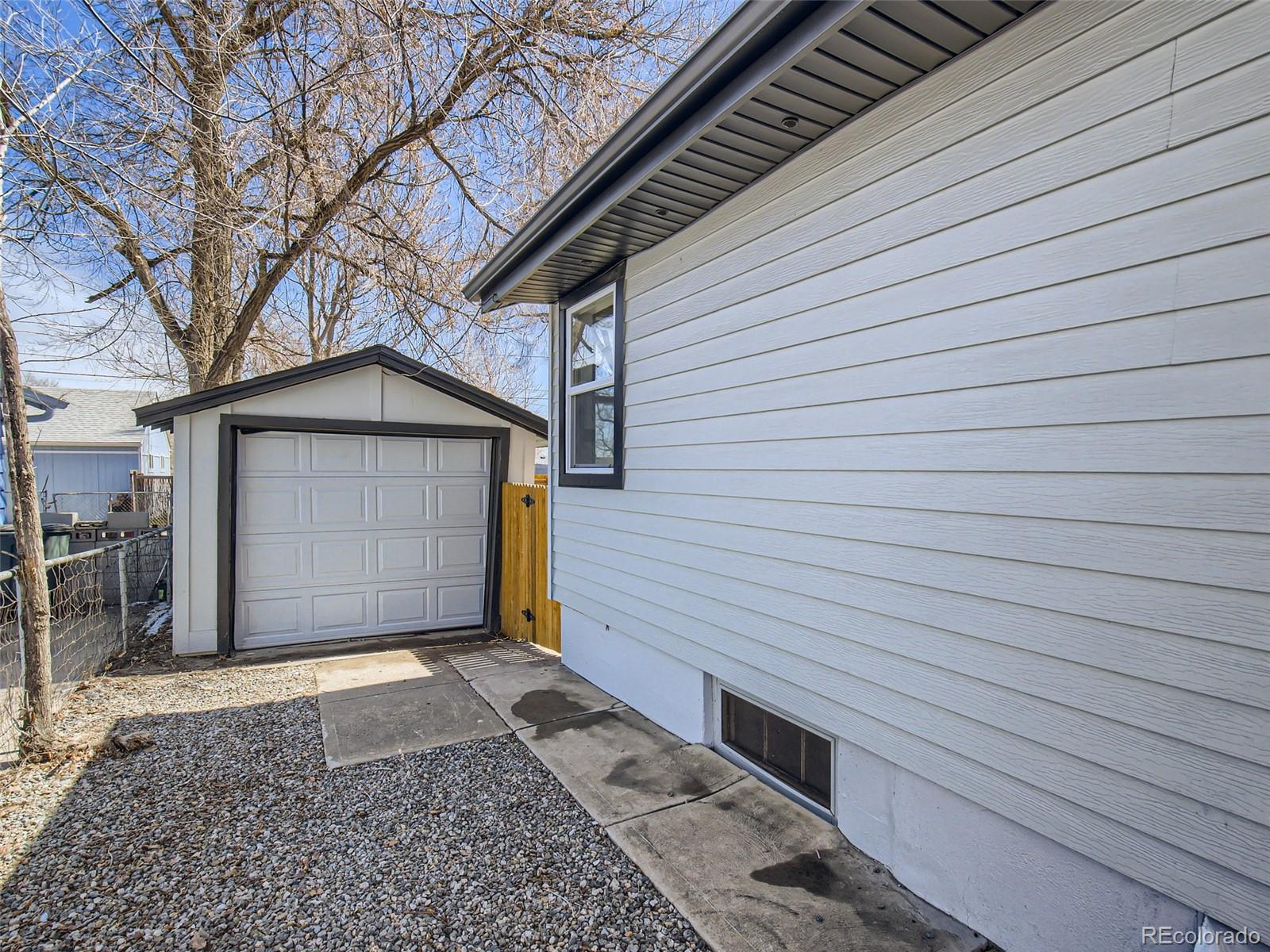 2814 Chase Street Wheat Ridge, CO 80214 - Photo 27 of 28 a view of a house with a small yard and garage