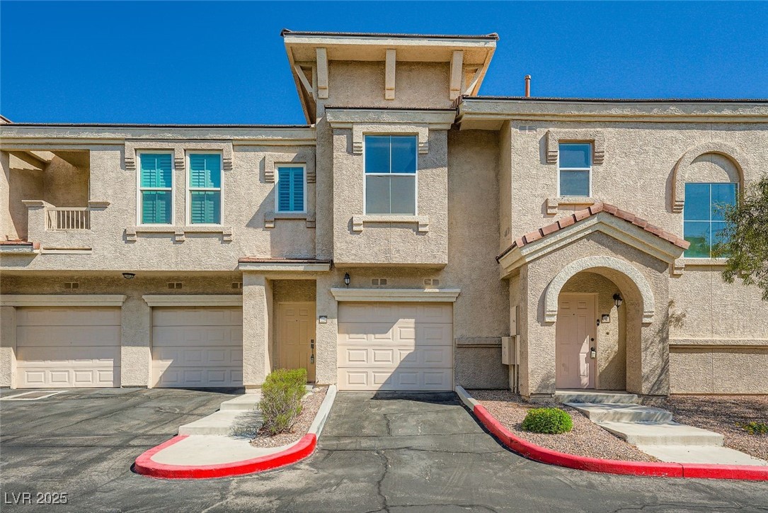 10550 West Alexander Road, Unit 2219 Las Vegas, NV 89129 - Photo 3 of 29 View of front facade with driveway, stucco siding, and an attached garage