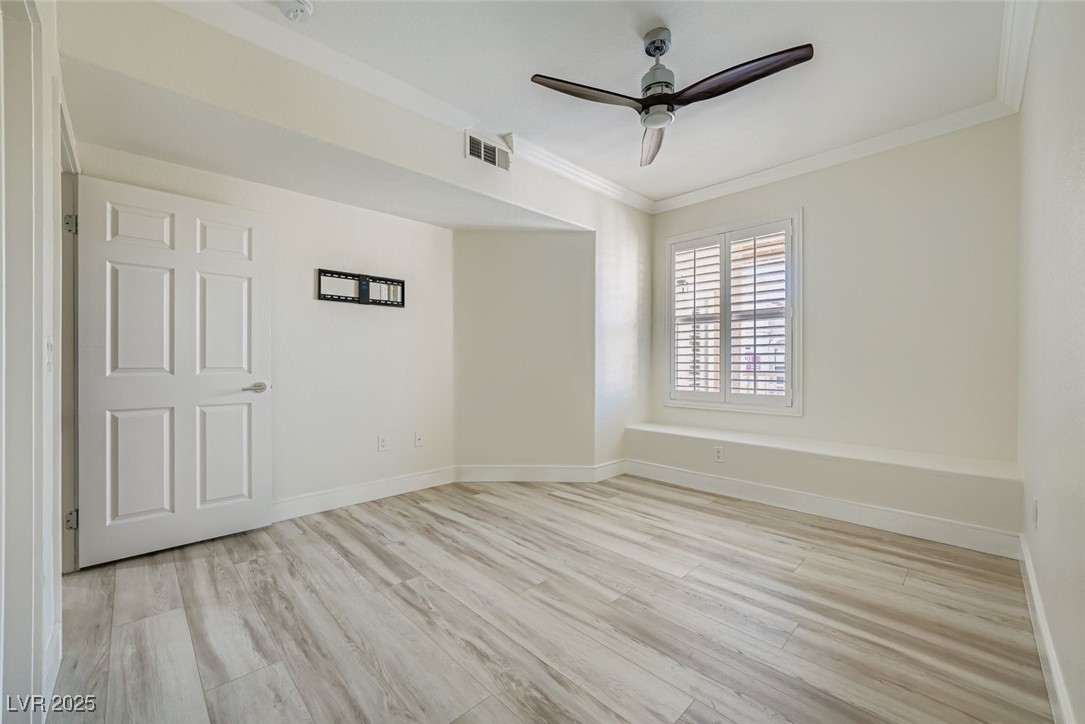 10550 West Alexander Road, Unit 2219 Las Vegas, NV 89129 - Photo 8 of 29 Unfurnished room with light wood-style floors, crown molding, and ceiling fan
