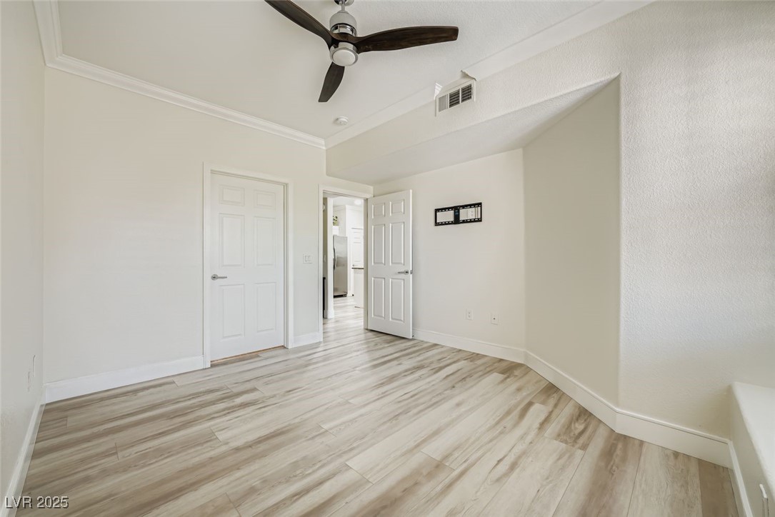 10550 West Alexander Road, Unit 2219 Las Vegas, NV 89129 - Photo 9 of 29 Unfurnished bedroom with light wood-type flooring, ornamental molding, a ceiling fan, and freestanding refrigerator