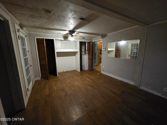 a view of empty room with wooden floor
