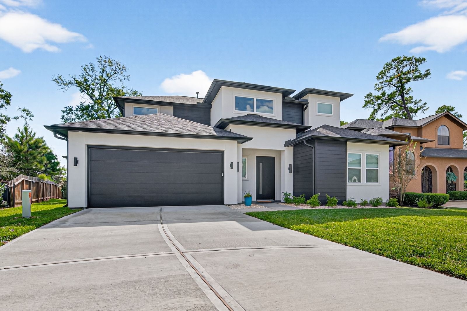 a front view of a house with a yard and potted plants