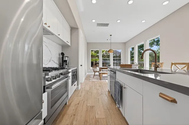a dining room with wooden floor a chandelier a wooden table and chairs