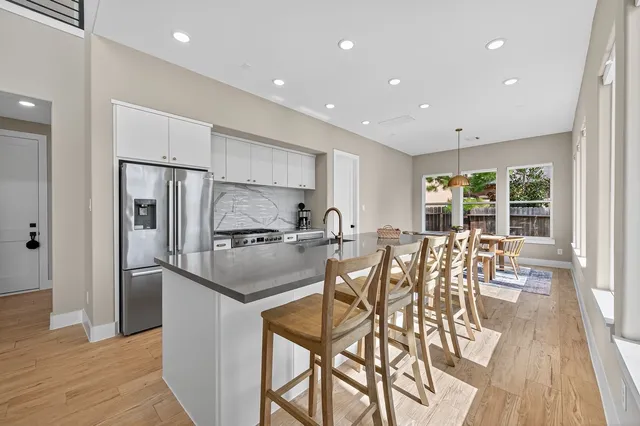 a kitchen with stainless steel appliances granite countertop a refrigerator and a table chair