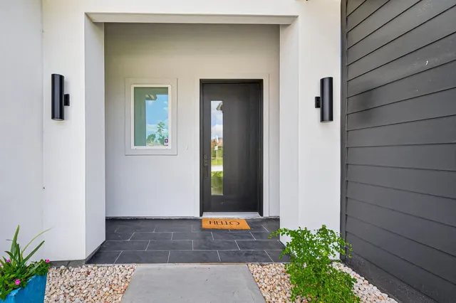 a front view of a house with a garden and plants