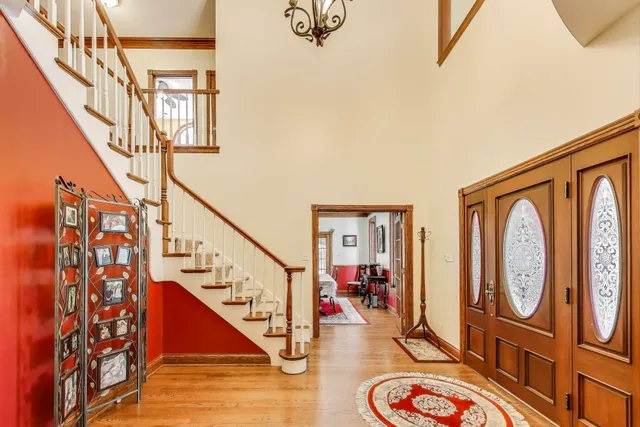 a view of a hallway with wooden floor and stairs