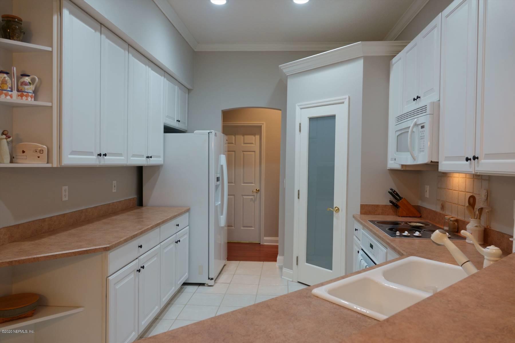 732 Mill Stream Road Ponte Vedra Beach, FL 32082 - Photo 7 of 19 a kitchen with a refrigerator and white cabinets