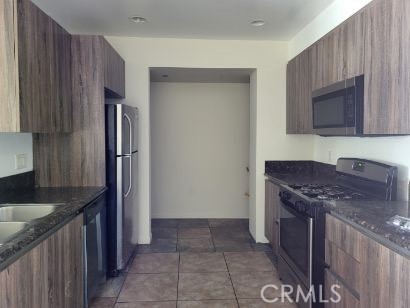 13190 Bromont Avenue, Unit 315 Sylmar, CA 91342 - Photo 6 of 10 a kitchen with stainless steel appliances granite countertop a stove a refrigerator and a sink