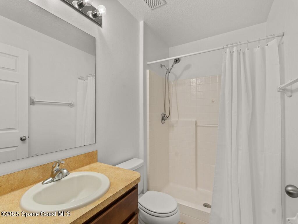4026 Meander Place, Unit 208 Rockledge, FL 32955 - Photo 16 of 32 a bathroom with a sink toilet a mirror and shower