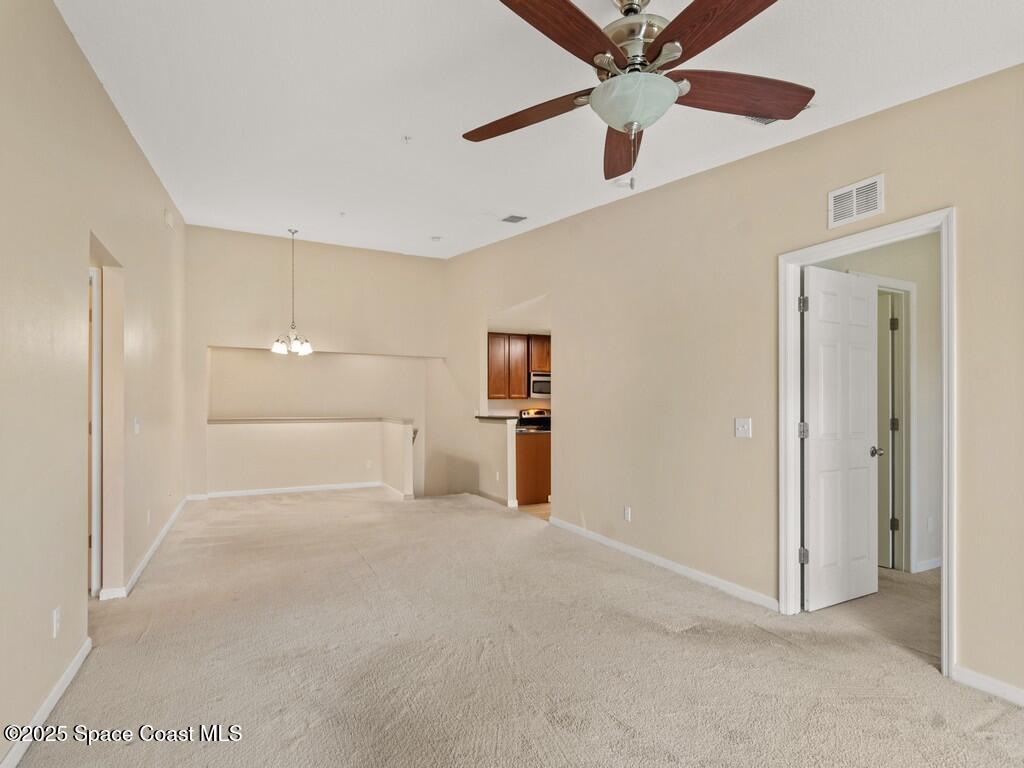 4026 Meander Place, Unit 208 Rockledge, FL 32955 - Photo 5 of 32 a view of a big room with wooden floor and a ceiling fan