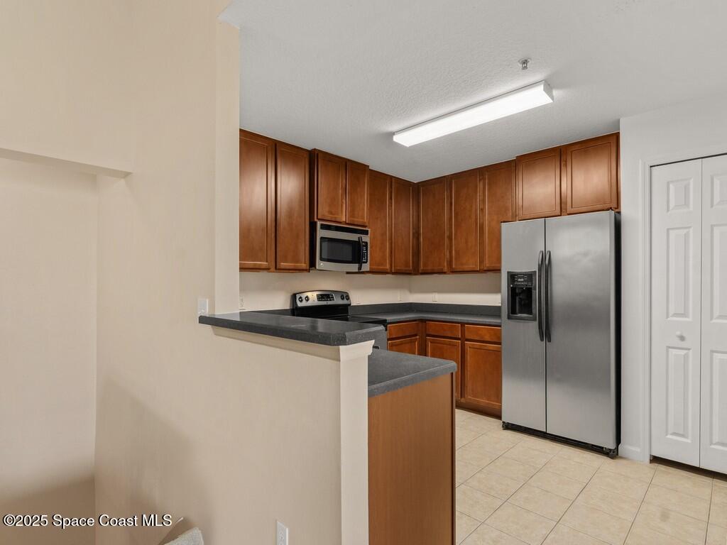 4026 Meander Place, Unit 208 Rockledge, FL 32955 - Photo 10 of 32 a kitchen with stainless steel appliances granite countertop a refrigerator a sink a stove a microwave and island
