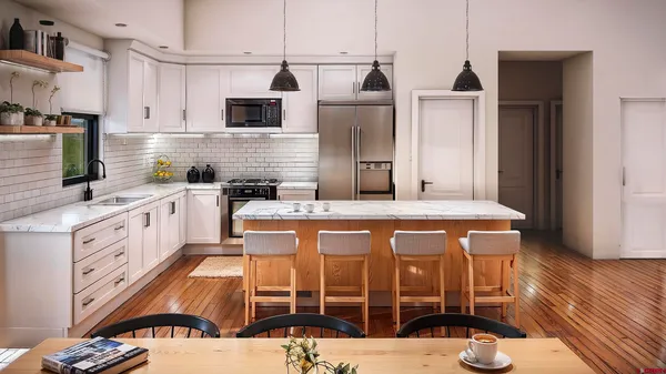 a kitchen with stainless steel appliances kitchen island granite countertop a stove a sink and a microwave