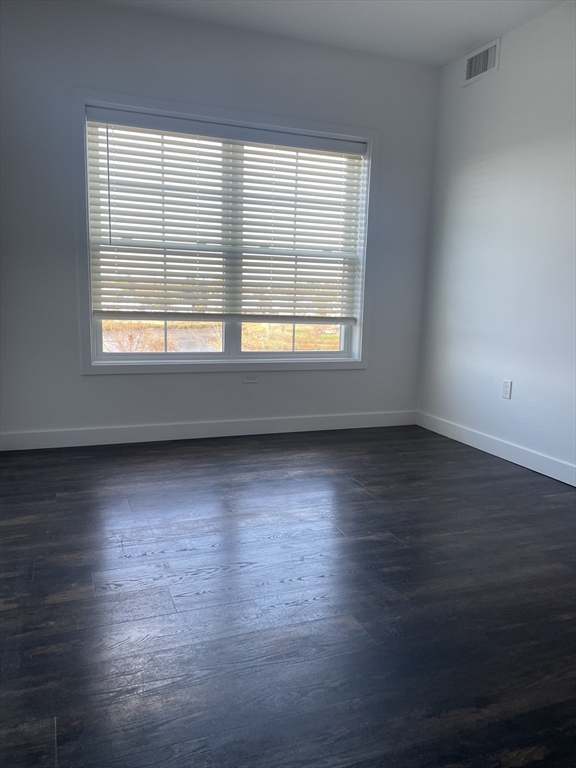 6 Needhams Landing Road, Unit 206 Lynn, MA 01905 - Photo 11 of 12 an empty room with wooden floor and windows