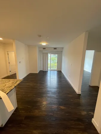 a view of empty room with wooden floor