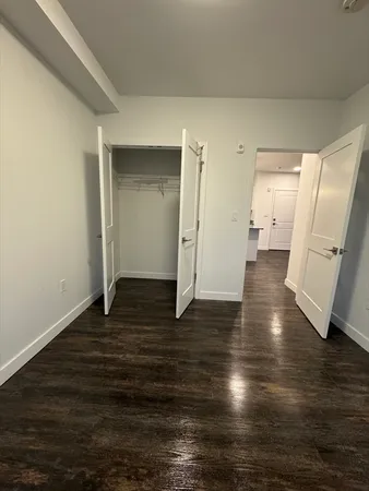 a view of a room with wooden floor and a kitchen