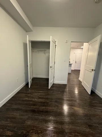 a view of a room with wooden floor and a kitchen