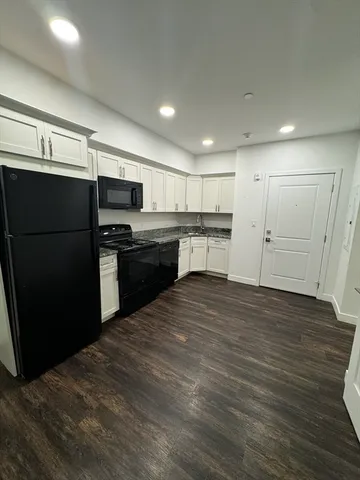 a kitchen with stainless steel appliances granite countertop a refrigerator and a stove top oven