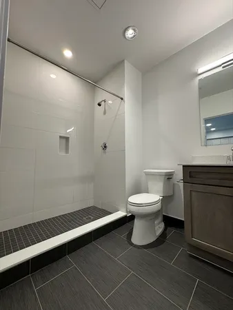 a bathroom with a toilet a sink and mirror