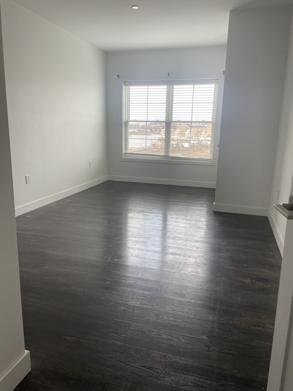 6 Needhams Landing Road, Unit 206 Lynn, MA 01905 - Photo 10 of 12 an empty room with wooden floor and windows