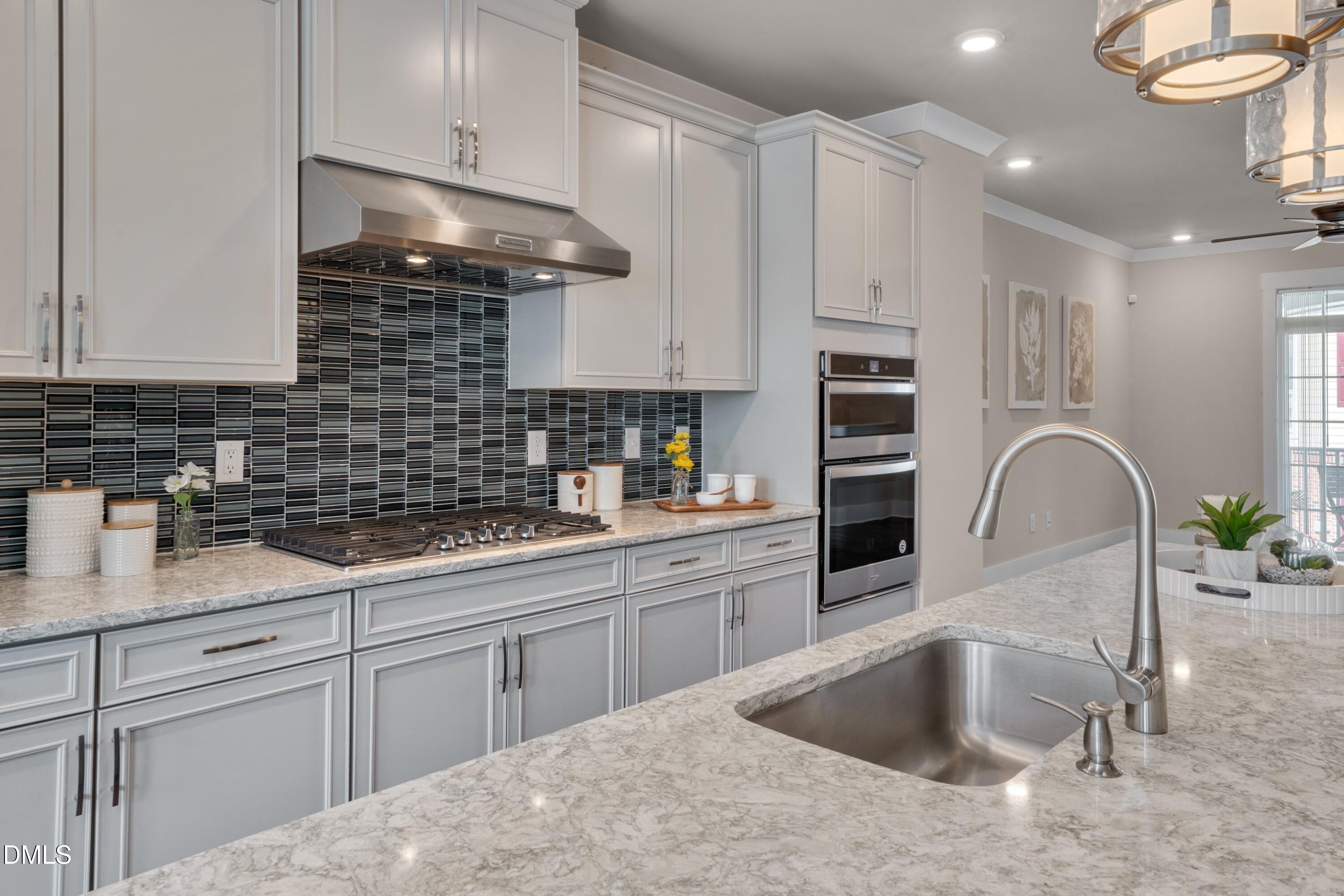 10330 Sablewood Drive, Unit 104 Raleigh, NC 27617 - Photo 6 of 39 a kitchen with white cabinets a sink and dishwasher