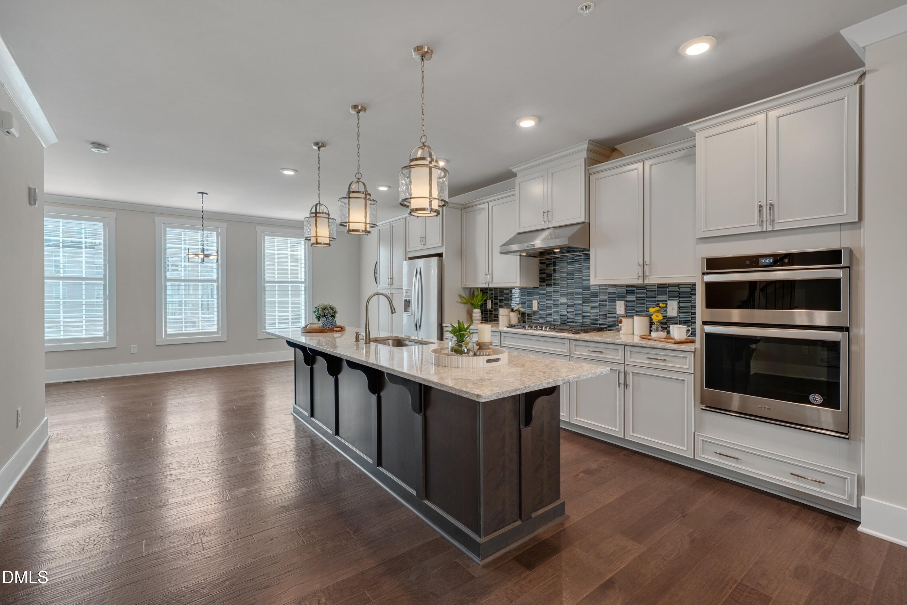 10330 Sablewood Drive, Unit 104 Raleigh, NC 27617 - Photo 3 of 39 a kitchen with stainless steel appliances granite countertop a kitchen island hardwood floor sink stove and white cabinets