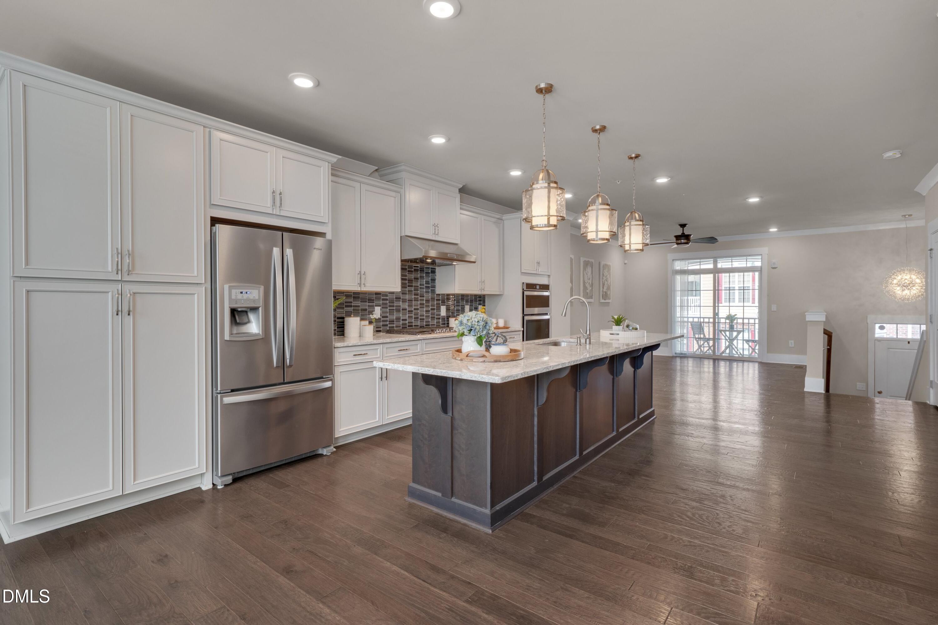 10330 Sablewood Drive, Unit 104 Raleigh, NC 27617 - Photo 4 of 39 a large kitchen with stainless steel appliances kitchen island a large counter top and wooden floors
