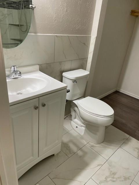 9831 West Walnut Street, Unit 206 Dallas, TX 75243 - Photo 19 of 21 a white toilet sitting next to a bathroom sink