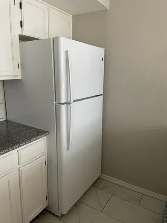 a white refrigerator freezer sitting in a kitchen