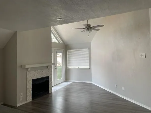 a view of empty room with a fireplace and wooden floor