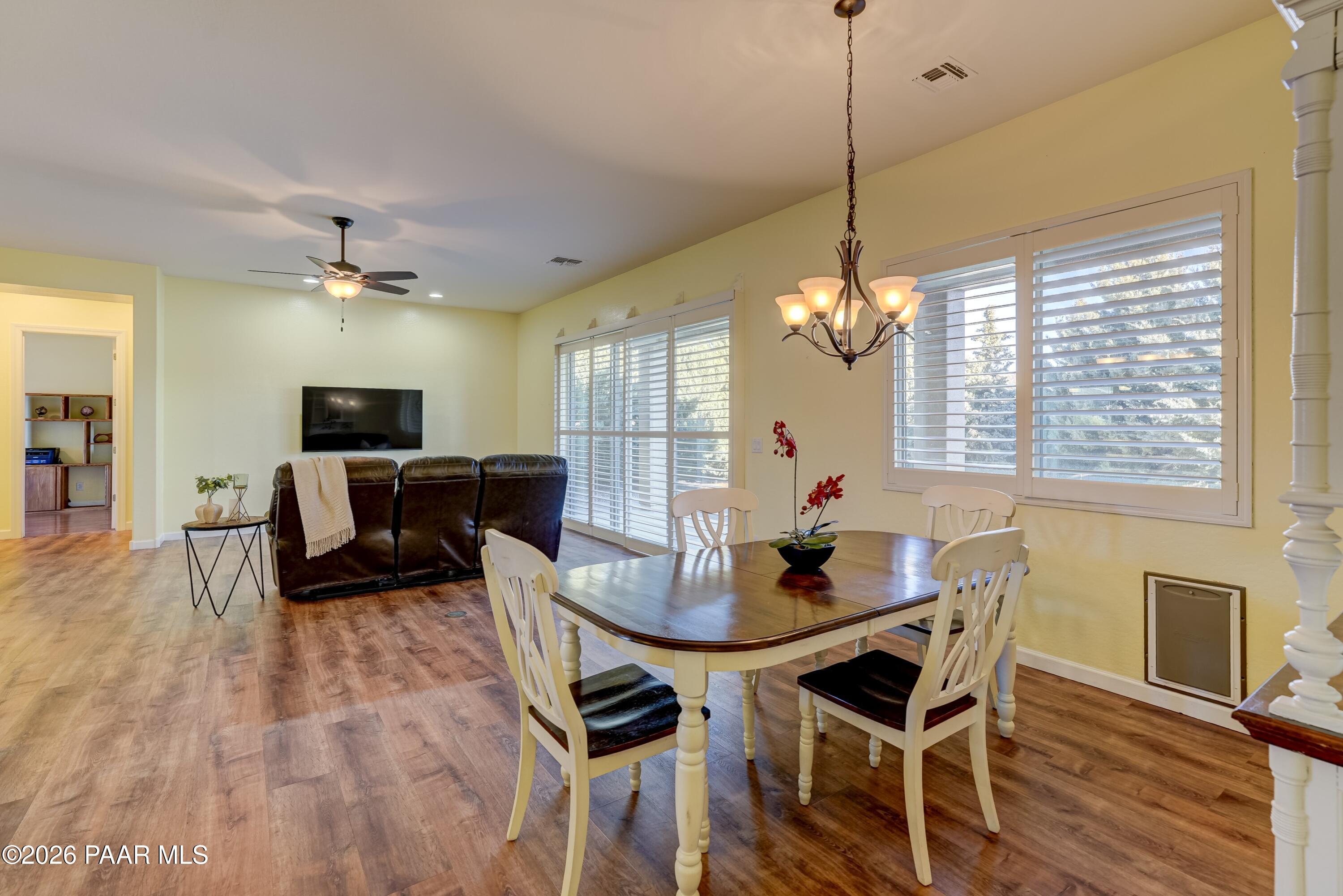 7106 East Prairie Ridge Road Prescott Valley, AZ 86315 - Photo 11 of 27 a living room with furniture a chandelier and a flat screen tv