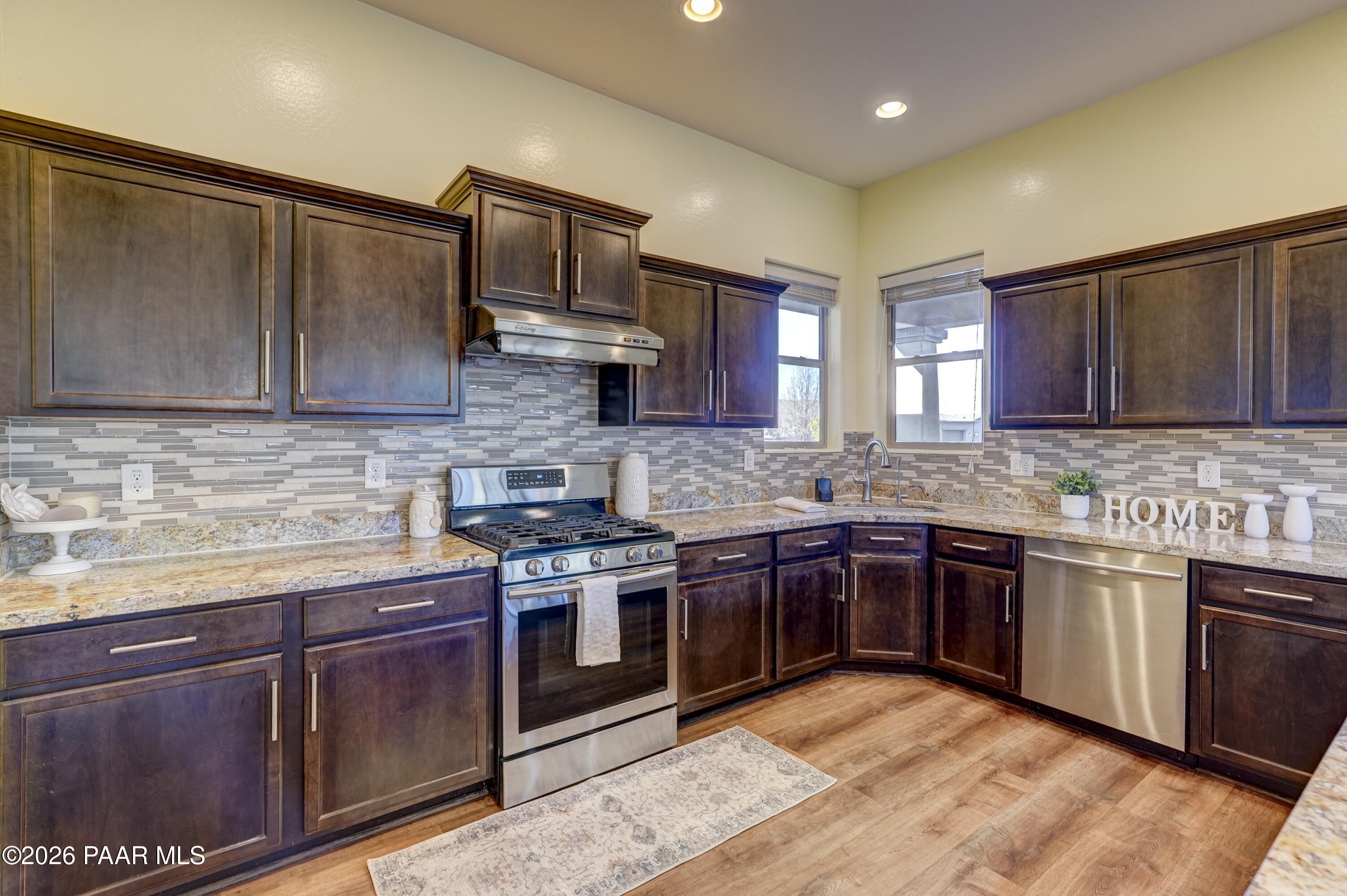7106 East Prairie Ridge Road Prescott Valley, AZ 86315 - Photo 7 of 27 a kitchen with stainless steel appliances granite countertop wooden cabinets granite counter tops and a stove