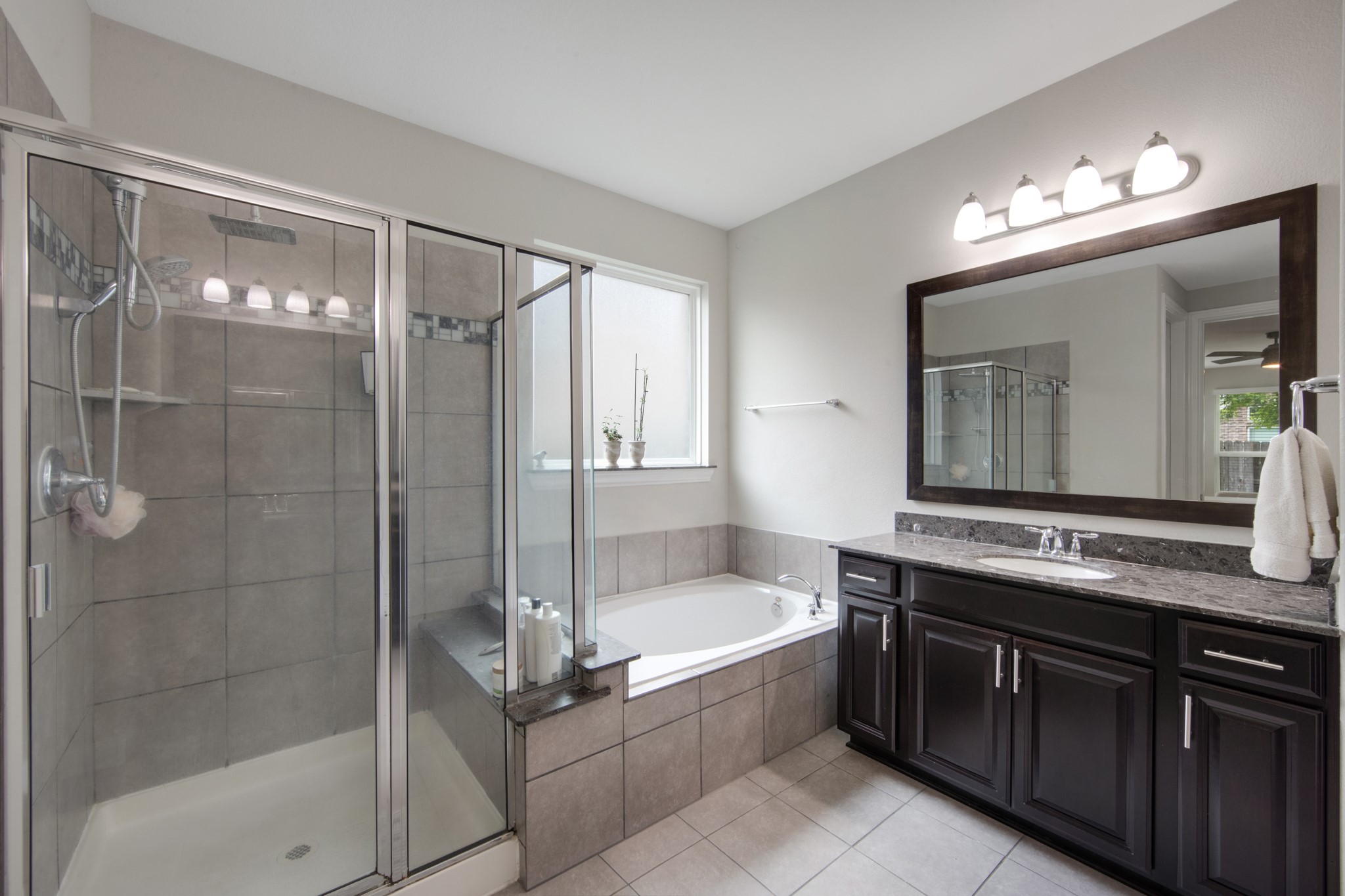 22622 Cutter Mill Drive Spring, TX 77389 - Photo 20 of 40 a bathroom with a bathtub a double vanity sink and a mirror