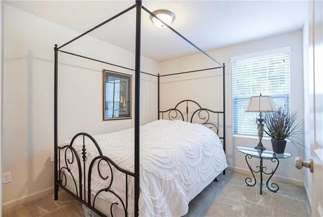a bedroom with a bed window and table in it
