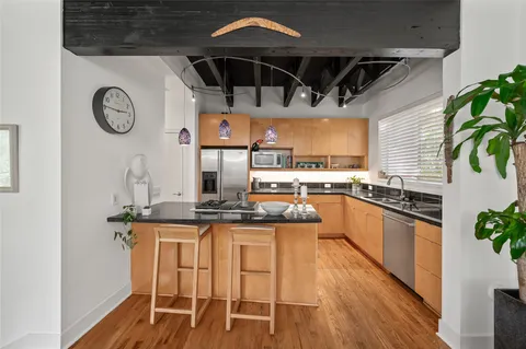 a kitchen with stainless steel appliances granite countertop a table and chairs