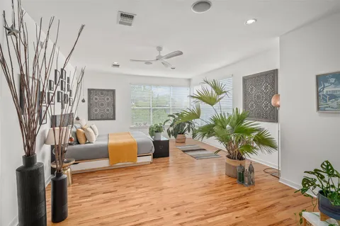 a living room with furniture flowerpot and wooden floor