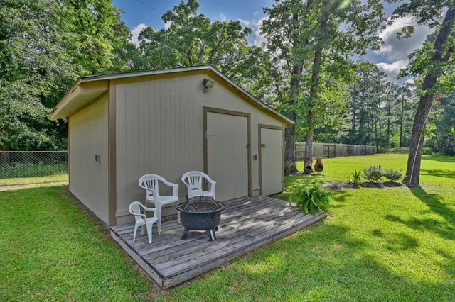 a view of a chair and table in backyard of the house