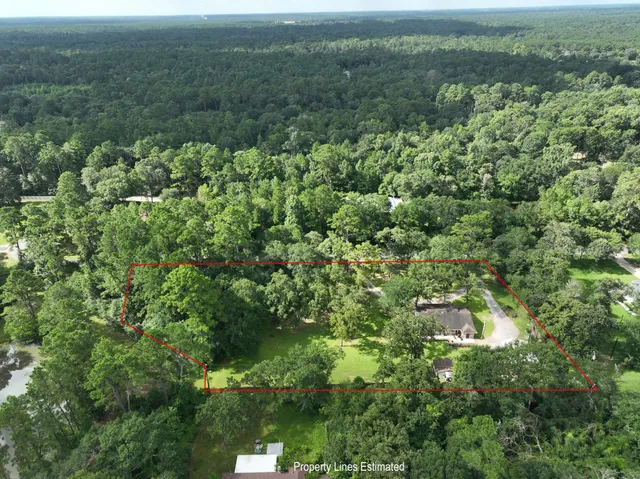 an aerial view of residential houses with outdoor space and trees