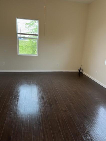 3112 Stonewall Street, Unit 3 Greenville, TX 75401 - Photo 3 of 5 an empty room with wooden floor and windows