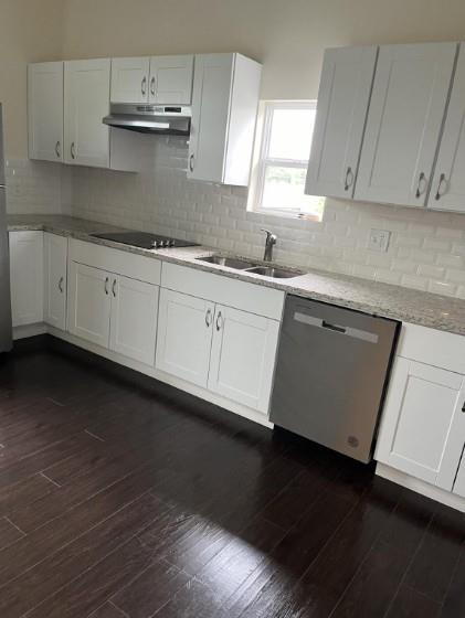 3112 Stonewall Street, Unit 3 Greenville, TX 75401 - Photo 5 of 5 a kitchen with granite countertop white cabinets and a wooden floor