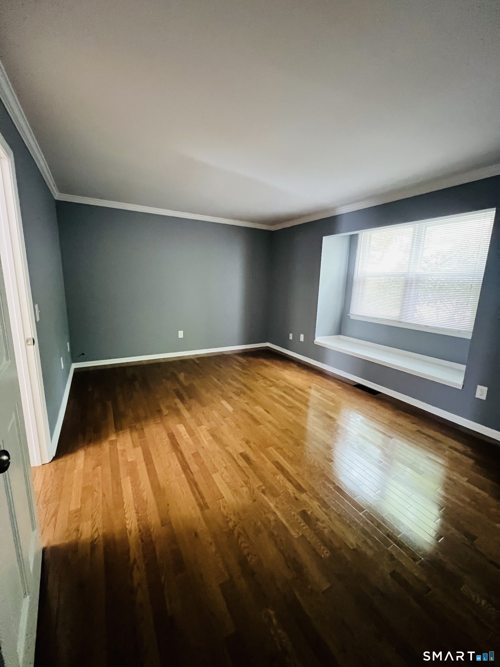 55 Mill Plain Road, Unit 297 Danbury, CT 06811 - Photo 5 of 8 an empty room with wooden floor and windows