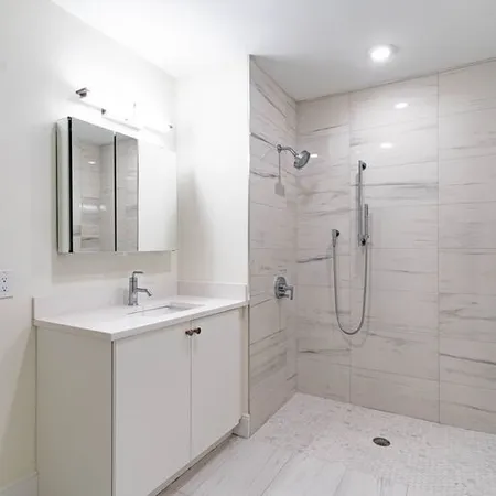 a bathroom with a shower sink and mirror